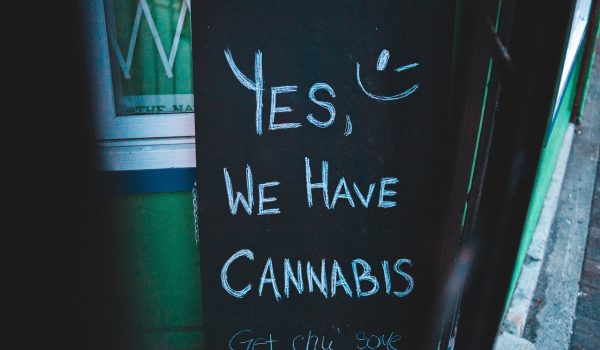 board with cannabis offer near wall of building